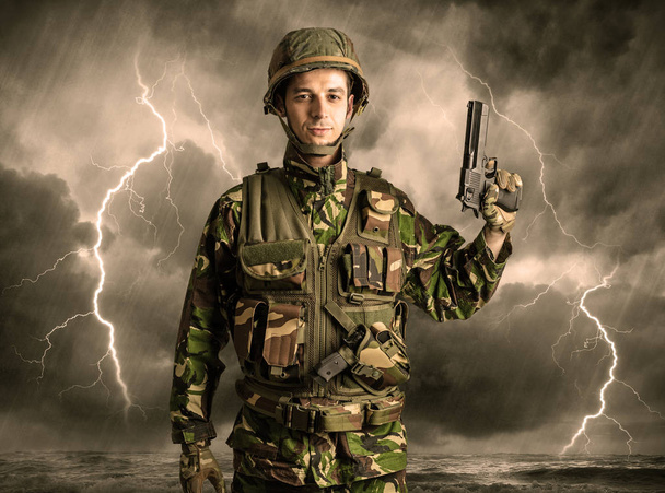 Armed soldier standing in an obscure weather - Photo, Image