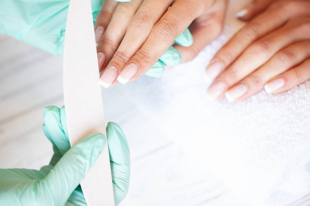 Professional manicure procedure. Nails master doing manicure in beauty studio - Zdjęcie, obraz