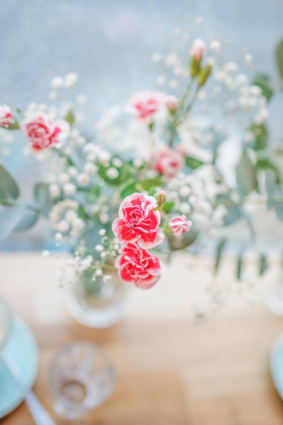 Pequeñas flores de clavel rojo sobre el fondo pastel. Copiar espacio
 - Foto, Imagen
