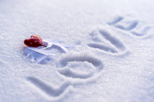 Izolované Origami papír chlapec a dívka, drželi se za ruce s červeným srdcem mezi nimi na pozadí bílého sněhu s prostorem pro Text - pojem lásky, štěstí a radosti na Valentýna - Fotografie, Obrázek