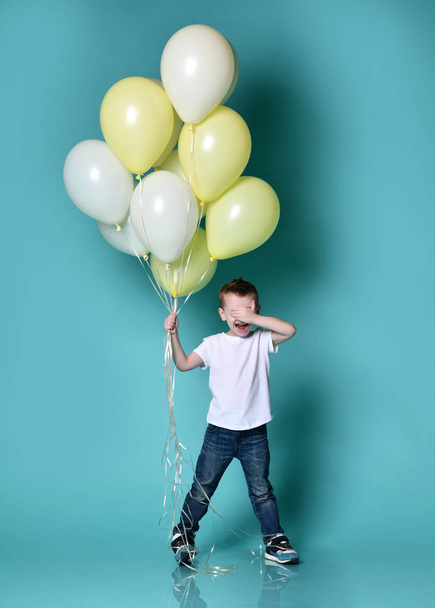 Cute kid holding a lot of balloons - Фото, зображення