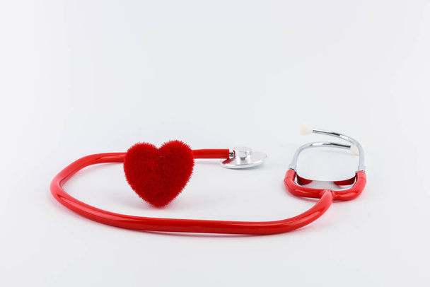Red heart and a stethoscope on white desk - Zdjęcie, obraz