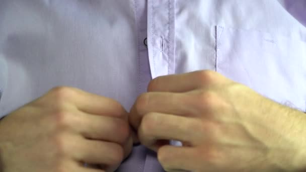 Een man vastmaakt een knop op shirt - Video