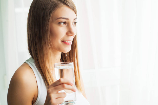 Terveellistä elämäntapaa. Lähikuva muotokuva nuori nainen juominen virkistävä puhdasta vettä lasista. Terveydenhuolto. Juotavaa. Vettä. Terveys, kauneus, ruokavalio käsite
 - Valokuva, kuva