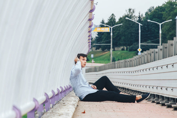 thoughtful stylish teenager relaxing alone on bridge - Foto, Imagem