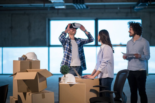 young team of business people in group, architect and engineer on construction site checking documents and business workflow using the virtual reality headset and laptop computer in new startup office - 写真・画像