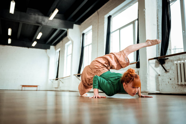 Professional yoga instructor with red hair doing hatha yoga - Photo, Image