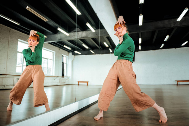 Beautiful professional modern dancer with red hair looking expressive - Foto, afbeelding