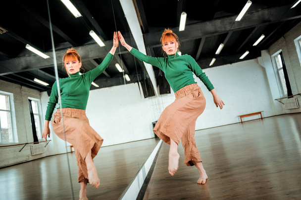 Red-haired professional dance teacher dancing near the mirror - Photo, image