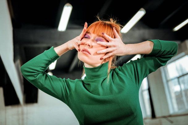 Red-haired professional choreographer with hair bun looking artistic - 写真・画像