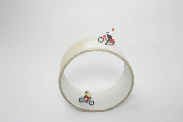een mini figuur rit motorfiets rond de cirkel - Foto, afbeelding