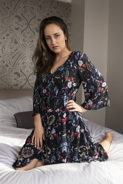 Petite young brunette in a long midnight blue print dress - Foto, afbeelding