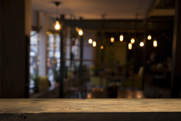 image of wooden table in front of abstract blurred background of resturant lights - Photo, Image