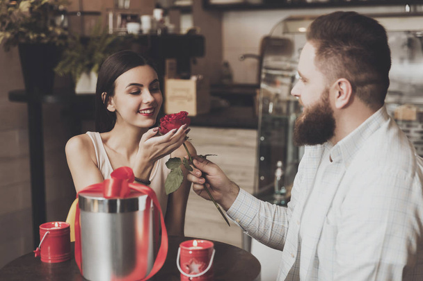 Bearded man gives a rose to beautiful smiling girl - Fotoğraf, Görsel