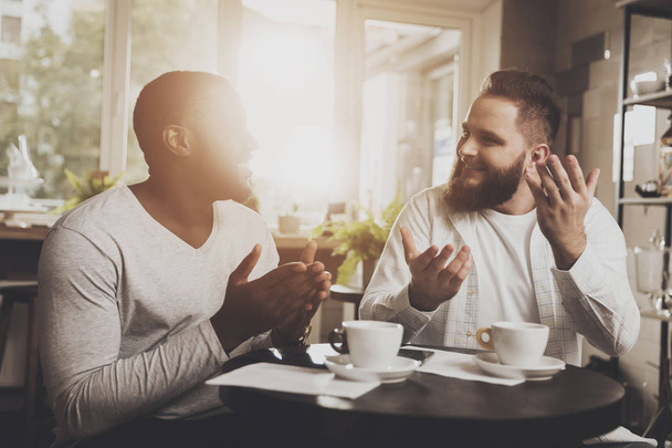 Multiethnic company of men communicates in a cafe - Foto, imagen