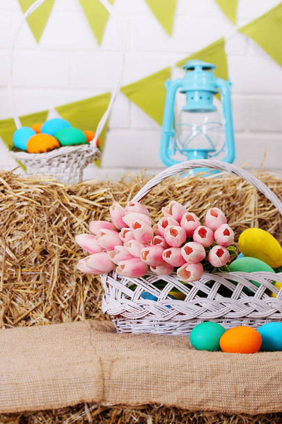Basket with a bouquet of tulips and colored eggs - Photo, Image
