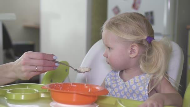 Een klein babymeisje wil niet eten van PAP en is stout. - Video