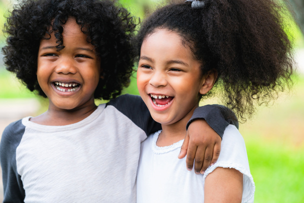 幸せな男の子と女の子公園で。庭で一緒に 2 つのアフリカ系アメリカ人の子供. - 写真・画像
