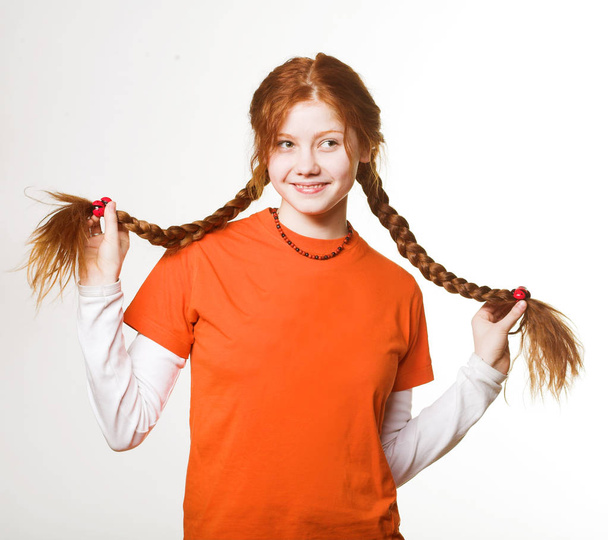 lovely redhead girl with long braids - Foto, afbeelding