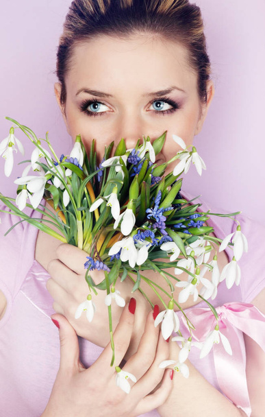 Young charming women holding in the hands of snowdrops - Photo, Image
