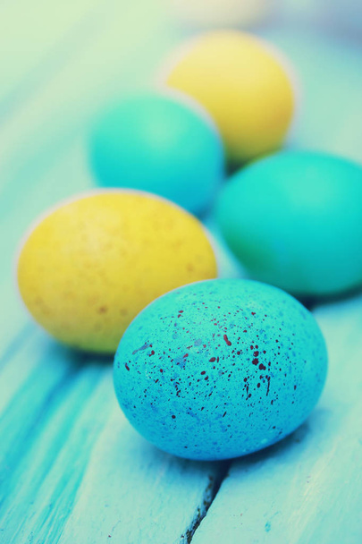 Spotted colored eggs on a wooden board - Photo, Image