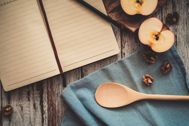 Cocinar un libro de recetas con nueces de manzana y cuchara en madera y
 - Foto, imagen
