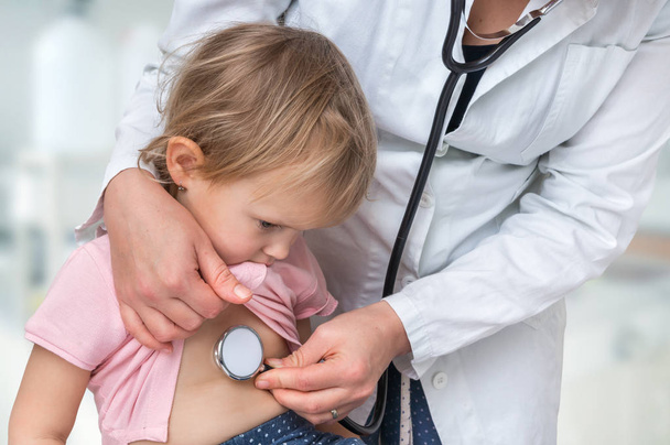 Médecin pédiatre examinant une petite fille par stéthoscope - concept de soins de santé
 - Photo, image