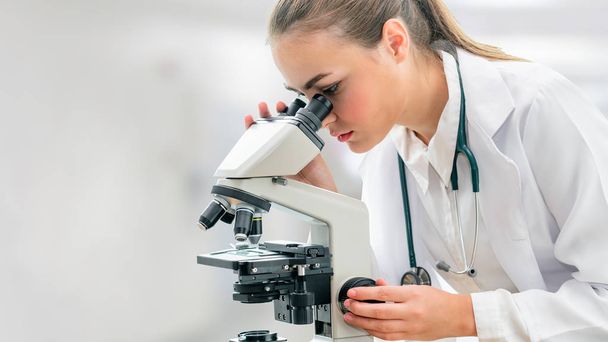 Scientist researcher using microscope in laboratory. Medical healthcare technology and pharmaceutical research and development concept. - Foto, Imagem