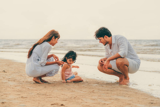 Happy family of father, mother and kids goes vacation on a tropical sand beach in summer. - Fotoğraf, Görsel