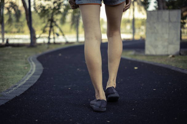 Zárja be a lábát. A lány az utcán sétál a parkban.. - Fotó, kép