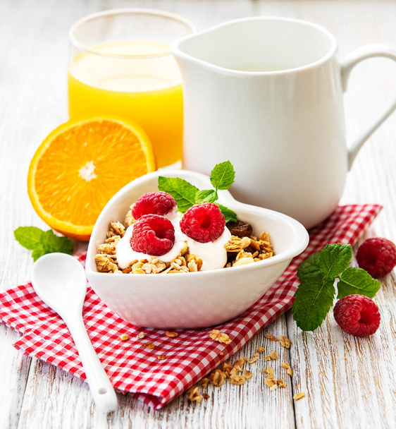 petit déjeuner sain, yaourt, baies fraîches et granola sur une table en bois blanc
 - Photo, image