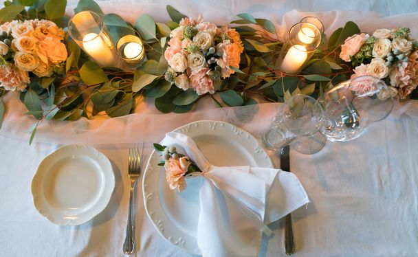 Tisch mit frischen Blumen und Kerzen für ein Hochzeitsessen - Foto, Bild