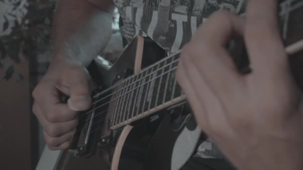 ein Mann spielt eine schwarze E-Gitarre - Filmmaterial, Video