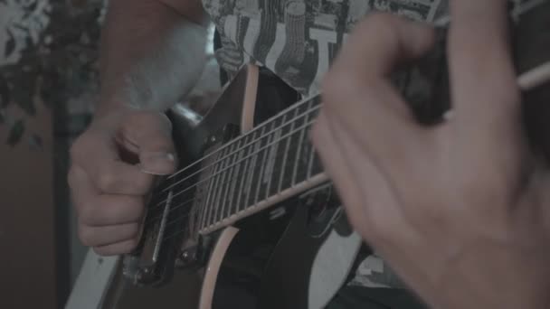 Een man speelt een zwarte elektrische gitaar - Video