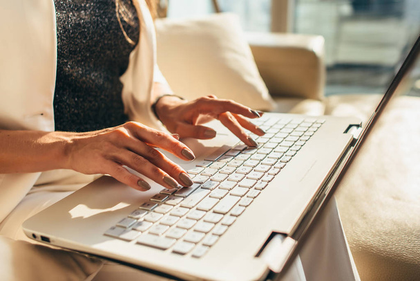 Nahaufnahme von Frauenhänden beim Tippen auf der Laptop-Tastatur - Foto, Bild