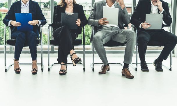 Bizneswoman i biznesmen trzymający CV folderu podczas oczekiwania na krzesła w biurze na rozmowę kwalifikacyjną. Koncepcja biznesu i zasobów ludzkich. - Zdjęcie, obraz
