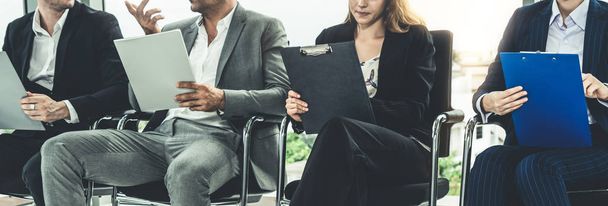 Businesswomen and businessmen holding resume CV folder while waiting on chairs in office for job interview. Corporate business and human resources concept. - Photo, Image