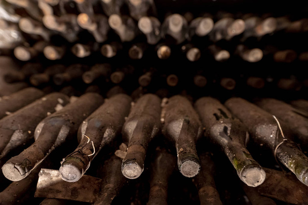 Bouteilles de vin poussiéreuses dans une cave souterraine
 - Photo, image