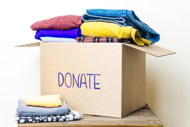 DONACIÓN DE ROPA Y CONCEPTO DE DONACIÓN ALIMENTARIA. Caja de donaciones con ropa y productos de higiene
. - Foto, imagen