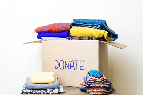 CLOTHES DONATION AND FOOD DONATION CONCEPT (em inglês). Caixa de doação com roupas e produtos de higiene
. - Foto, Imagem