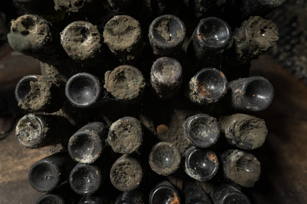Μπουκάλια κρασί γήρανσης καλύπτονται σε σκόνη και μούχλα - Φωτογραφία, εικόνα