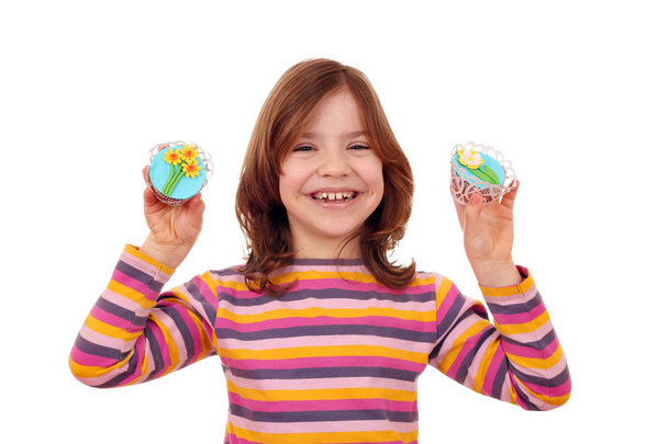 happy little girl with cupcakes decorated as spring flowers - Foto, afbeelding