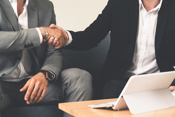 Businessman handshake with another businessman partner in modern workplace office. People corporate business deals concept. - Photo, Image