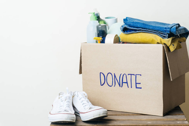CLOTHES DONATION AND FOOD DONATION CONCEPT. Donation box with clothes and hygiene products. Copy space - Foto, Imagen