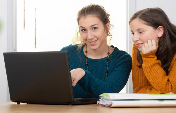 young woman helps a teen girl with  homework - Fotoğraf, Görsel