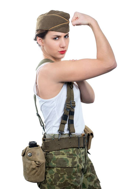a young woman dressed in wwii military uniform show her biceps - Foto, afbeelding