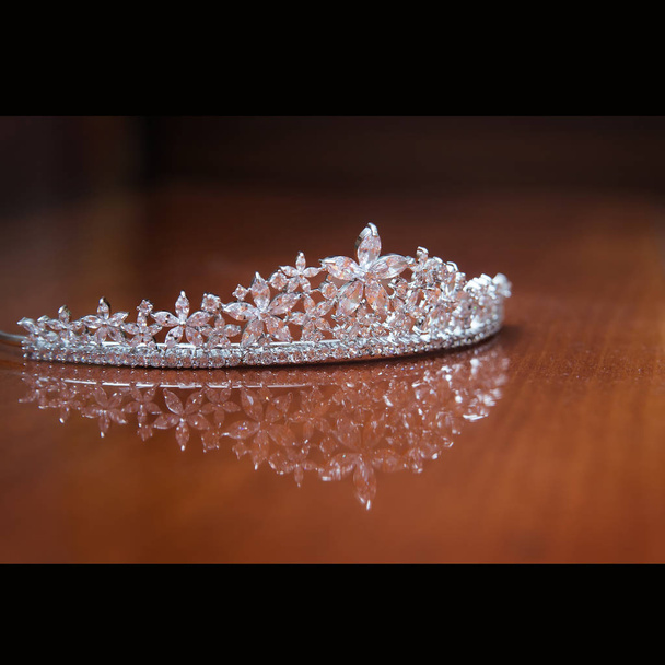 Luxe kroon met edelstenen op bruine achtergrond  - Foto, afbeelding