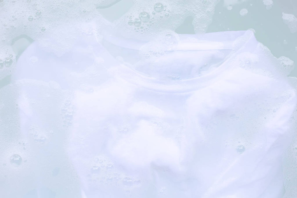 Remojar un paño antes de lavar, camiseta blanca
 - Foto, imagen