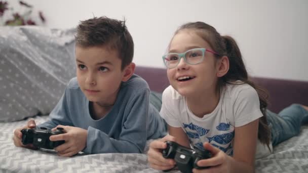 Happy παιδιά παίζει βίντεο παιχνίδι με χειριστήριο στο σπίτι. Φίλοι παίζουν κονσόλα παιχνιδιών - Πλάνα, βίντεο