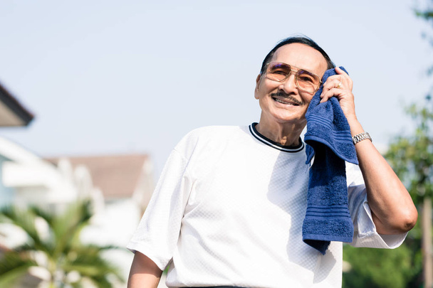 Een oudere man afvegen zijn zweet met servet - Foto, afbeelding